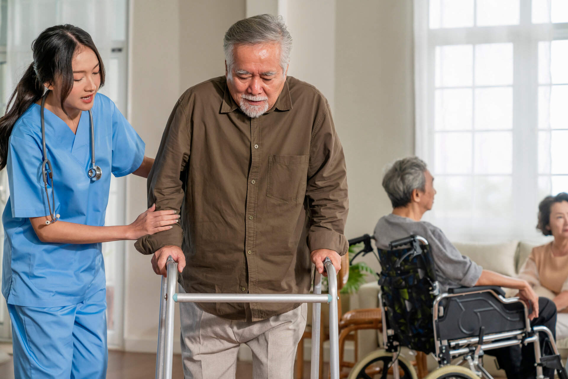 Professional nurse helping senior patient with walker